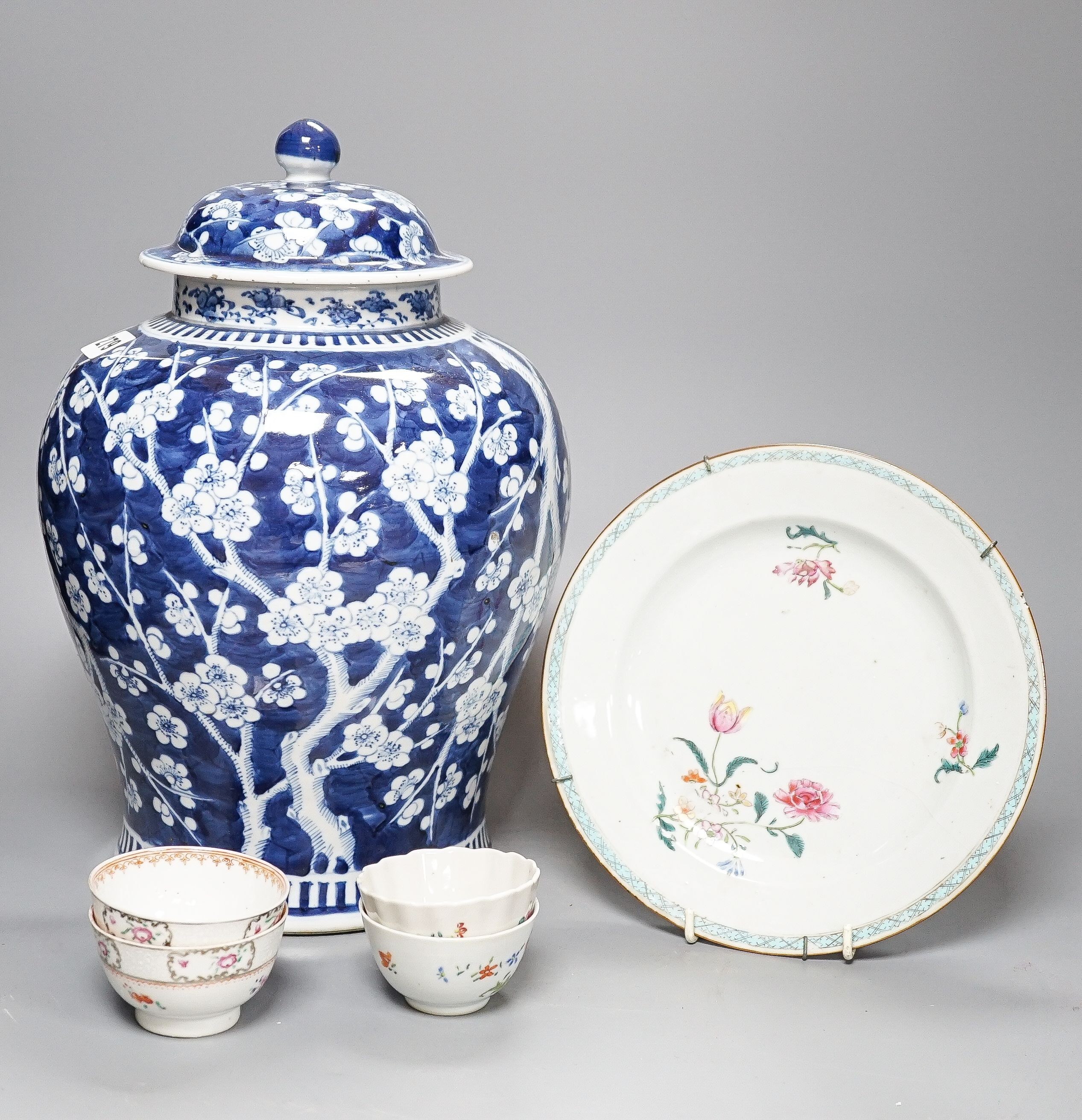 A 19th century Chinese blue and white Prunus jar and cover, 36cm and a group of 18th century Chinese export famille rose tea bowls and a plate